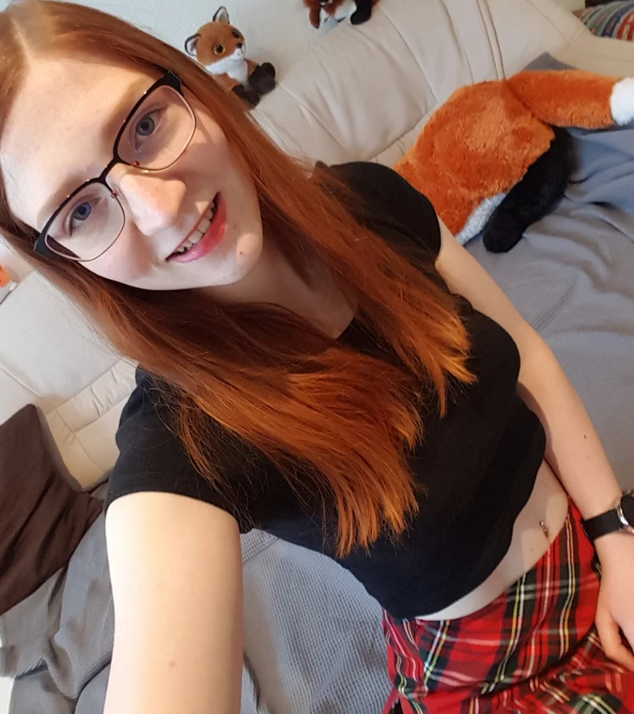 Selfie von Dekolleté mit schwarzem bauchfreiem Oberteil und Schottenrock